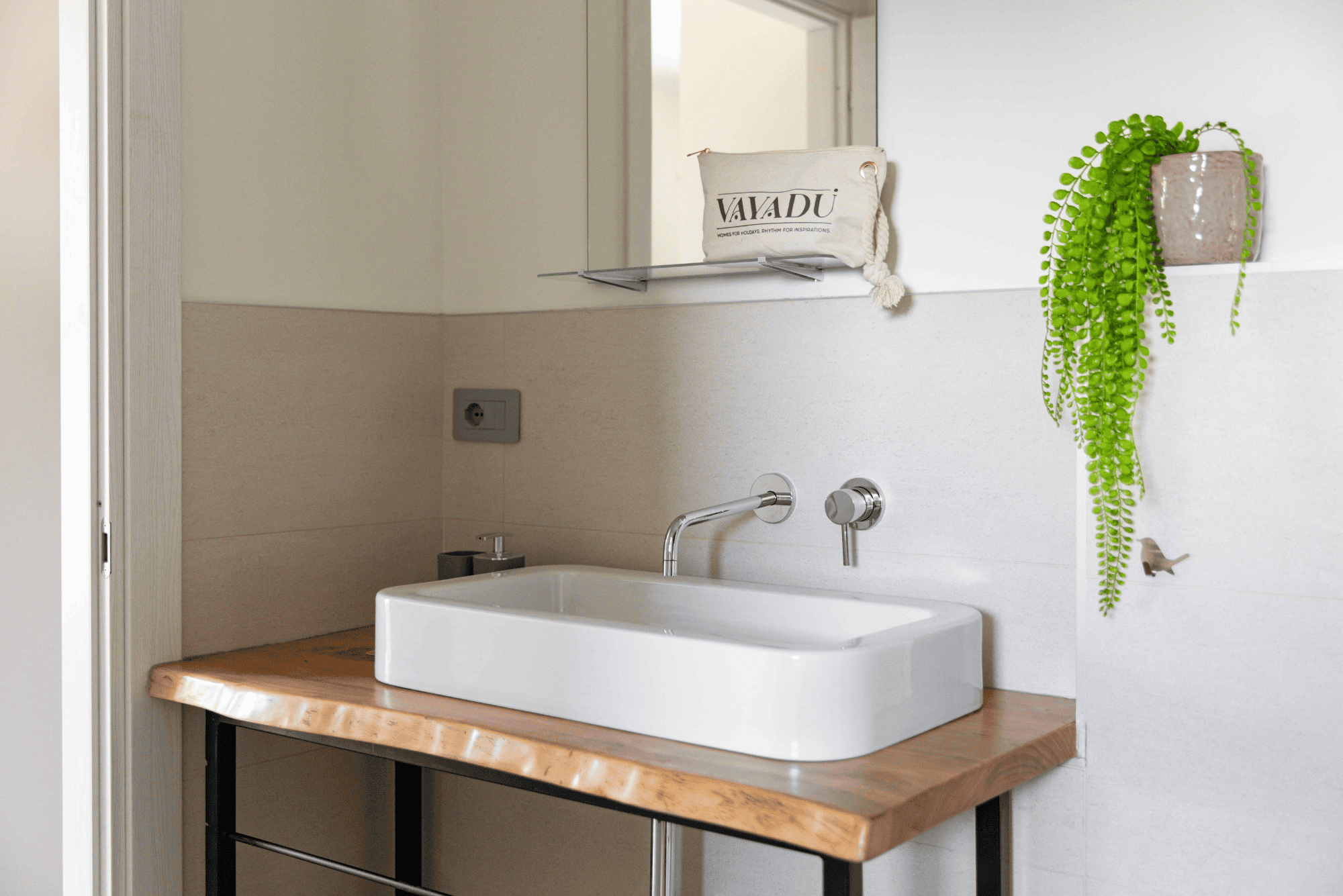 Un lavabo bianco appoggiato su un piano di legno chiaro
