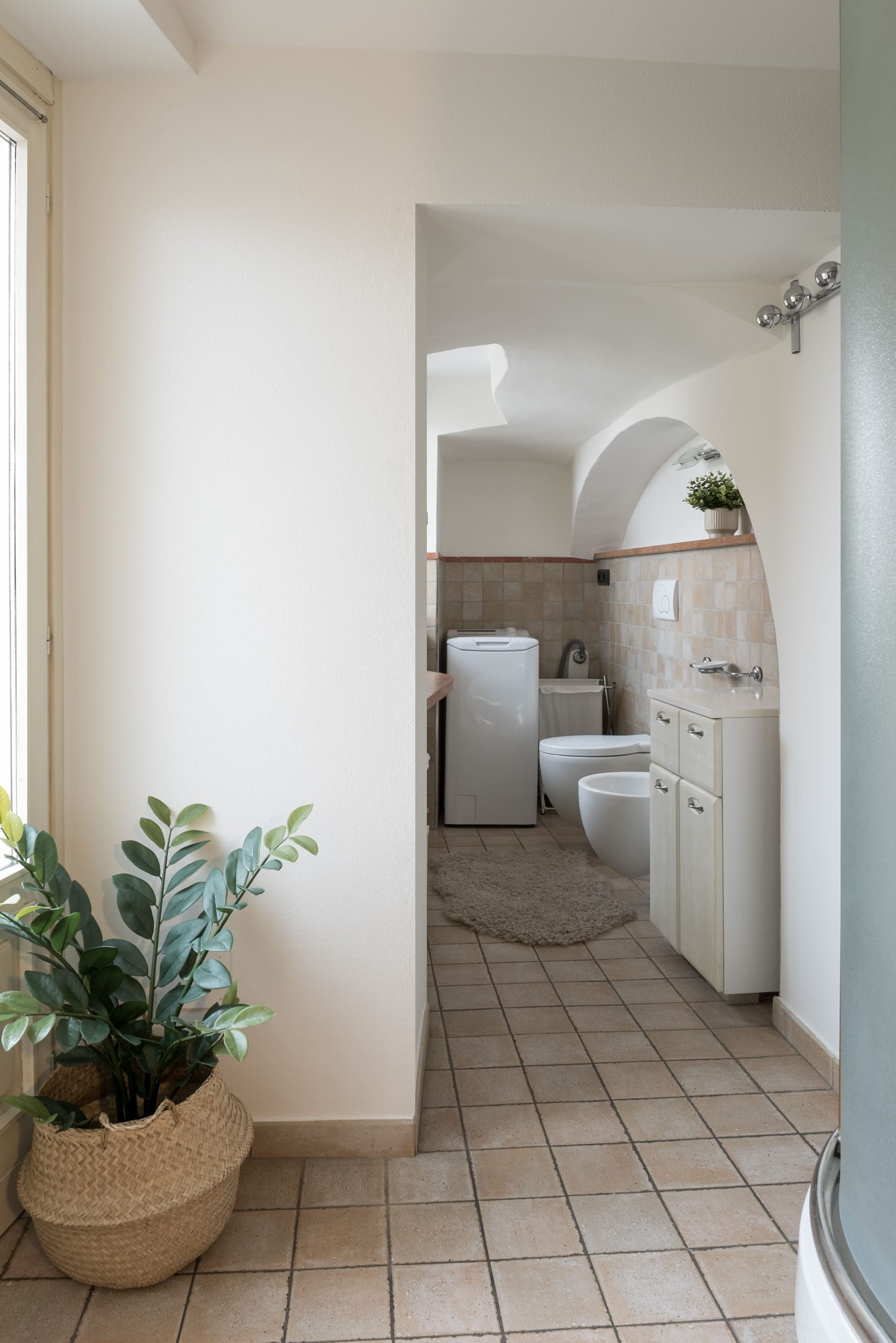 Il bagno con doccia, lavatrice e sanitari