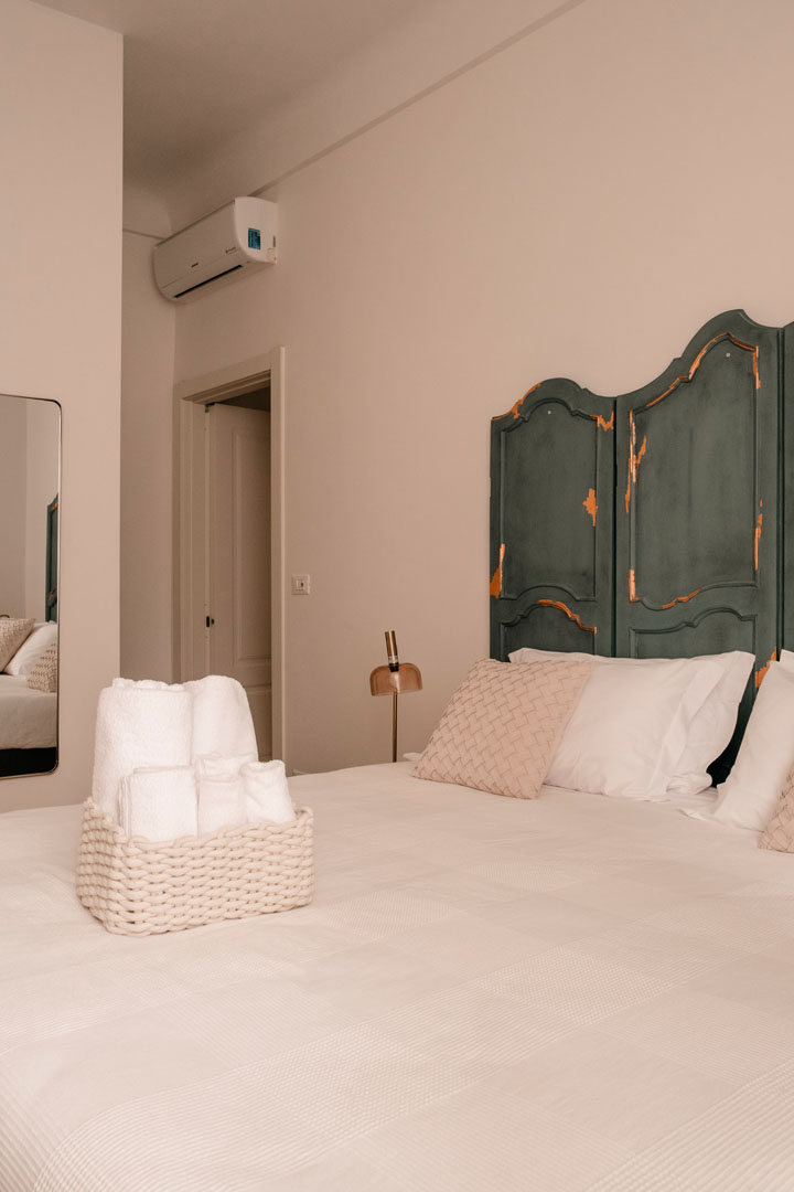Saubere Wäsche über dem Bett, als Zeichen des Willkommens, im Gästehaus Ensemble Rooms.