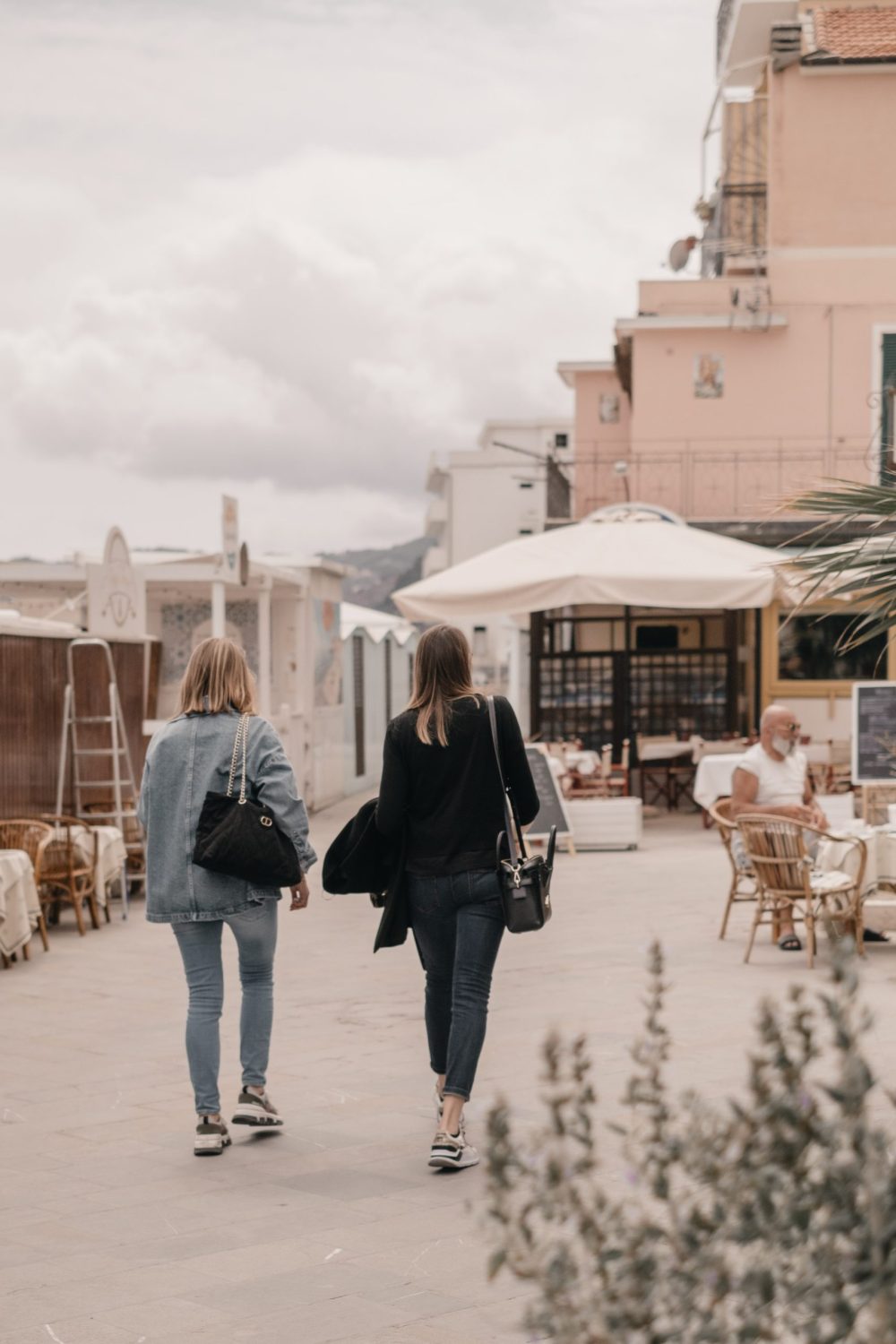 Due donne ritratte di spalle mentre passeggiano ad Alassio.