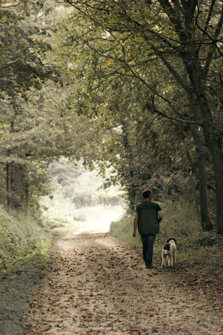 Un trifulau e il suo cane passeggiano nel bosco alla ricerca di tartufi