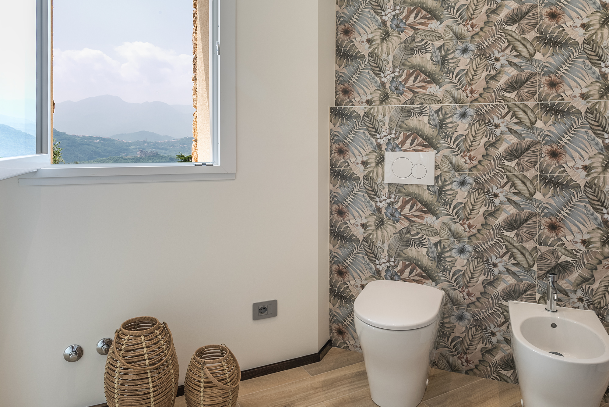 I sanitari nel bagno finestrato e con piastrelle jungle della casa vacanza a Finale Ligure